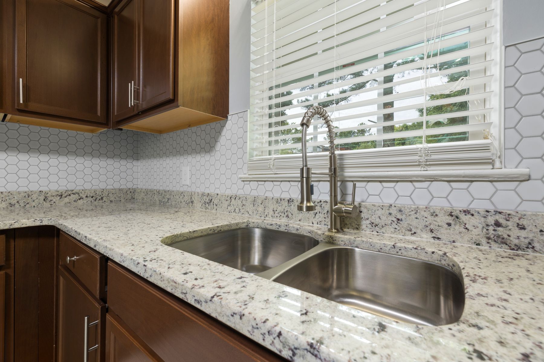 Installed stainless steel sink shown in a finished kitchen setting