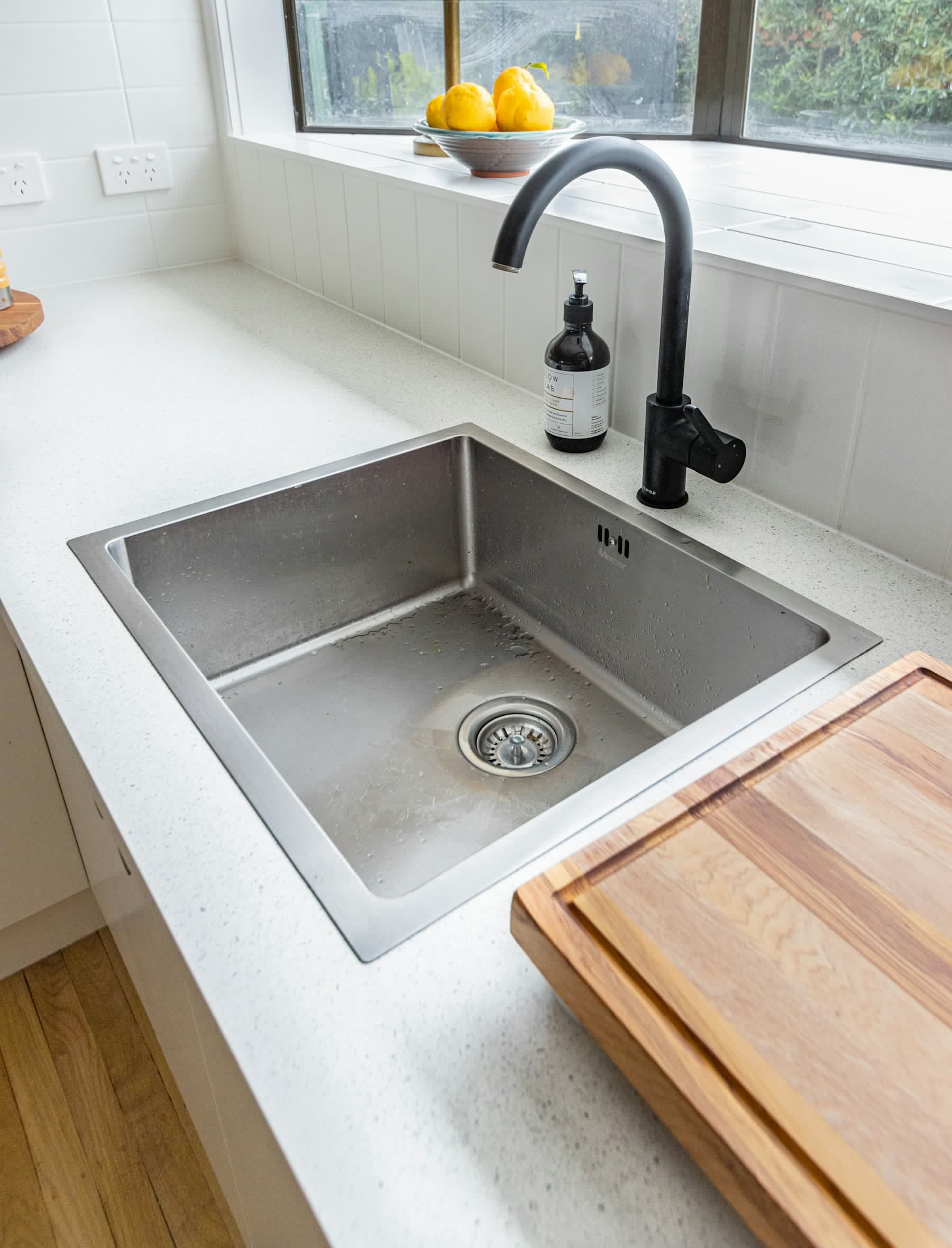 Installed stainless steel kitchen sink showing the bowl, rim, drain and finished surface